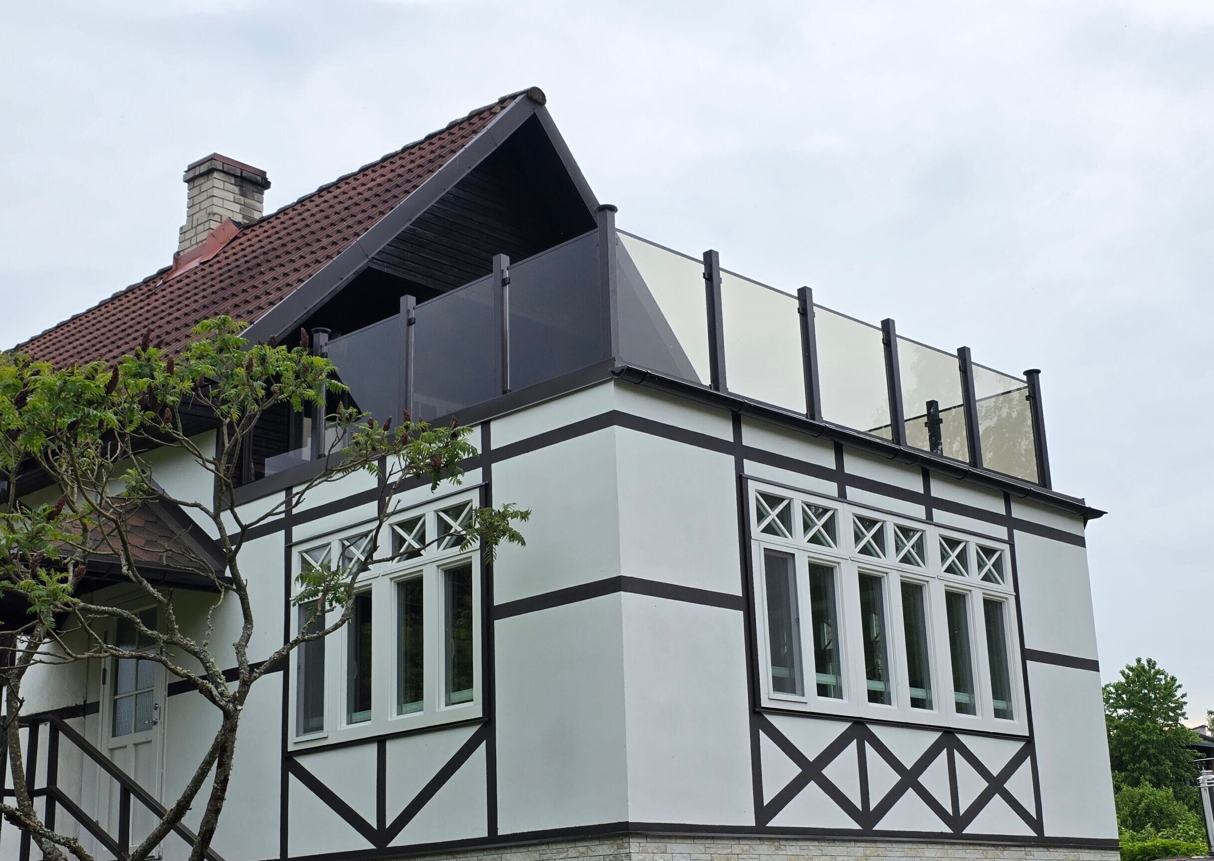 Klaaspiirdega katuseterrass renoveeritud elumajal.