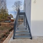 Sirge restastmetega metallist välistrepp piki valge hoone seina